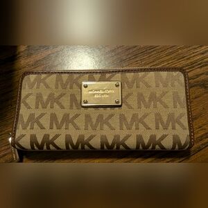 Used Michael Kors tan zip around wallet.